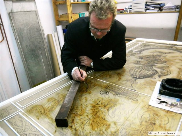 Der Künstler Werner Goll demonstriert des Auftrag des Asphaltlacks
